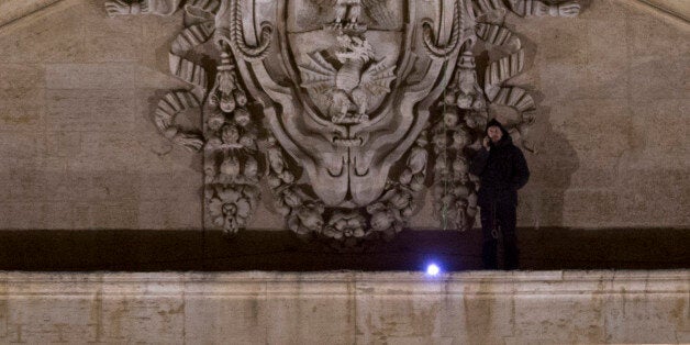 Italian entrepreneur Marcello di Finizio talks on the phone as he stands on the facade of St. Peterâs Cathedral at the Vatican, Sunday, Dec. 21, 2014. Marcello di Finizio lowered himself Sunday onto a narrow ledge on the facade of St. Peterâs Cathedral, the fifth time he has evaded Vatican security to mount a public protest against government reforms from one of Roman Catholicismâs holiest sites. Marcello di Finizio told the Associated Press by telephone from his perch overlooking