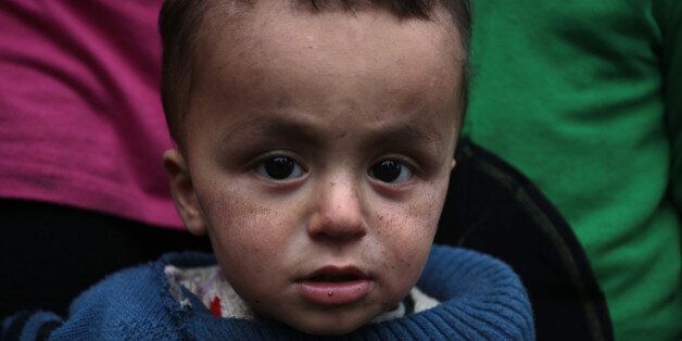 The ash covered face of one-year-old Mayar Abdo from Syrian as he stands with his family near an open fire in front of their unheated tents in a refugee camp in the town of Harmanli, Bulgaria, Thursday, Nov. 21, 2013. Thousands of Syrian and other refugees from the Middle East, Asia and Africa, who find enough courage to make a dangerous journey from their war-ravaged states, often end up in the crammed settlements in the Balkans, including Bulgaria, Greece or Serbia, after being caught on the borders of wealthy Western European nations for attempting to cross illegally. (AP Photo/Valentina Petrova)