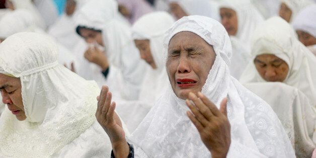 An Acehnese woman weeps during a prayer for the victims of Indian Ocean tsunami ahead of its 10th anniversary at Baiturrahman Grand Mosque in Banda Aceh, Aceh province, Indonesia, Thursday, Dec. 25, 2014. Some 230,000 people were killed in the tsunami set off by a magnitude 9.1 earthquake on Dec. 26, 2004, most of them in Aceh. (AP Photo/Heri Juanda)