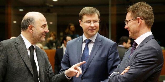 European Commissioner for Economic and Financial Affairs Pierre Moscovici, left, talks with European Commissioner for Jobs, Growth, Investment and Competitiveness Jyrki Katainen, right, and European Commissioner for Euro and Social Dialogue Valdis Dombrovskis, during the EU Finance Ministers meeting, at the European Council building in Brussels, Tuesday, Dec. 9, 2014. (AP Photo/Yves Logghe)