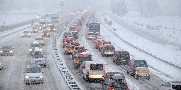 Snow fall as vehicles move bumper-to-bumper along the motorway near Albertville, on December 27, 2014 as they make their way into the Tarentaise valley in the heart of the French Alps, home to many of the famous French ski resorts. AFP PHOTO / Jean-Pierre CLATOT (Photo credit should read JEAN-PIERRE CLATOT/AFP/Getty Images)