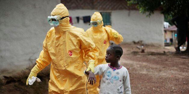 FILE - In this Sept. 30, 2014, file photo, Nine-year-old Nowa Paye is taken to an ambulance after showing signs of the Ebola infection in the village of Freeman Reserve, about 30 miles north of Monrovia, Liberia. (AP Photo/Jerome Delay, File)