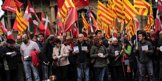 Pro-independence demonstrators of Catalonia and Basque Country raise their regional flags as they gather on a square to support an informal independence poll to celebrate in Catalonia, in Pamplona northern Spain, Sunday, Nov. 9, 2014. The pro-independence regional government of Catalonia stages a symbolic poll on secession in a show of determination and defiance after the Constitutional Court suspended its plans to hold an official independence referendum following a legal challenge by the Spanish government. (AP Photo/Alvaro Barrientos)