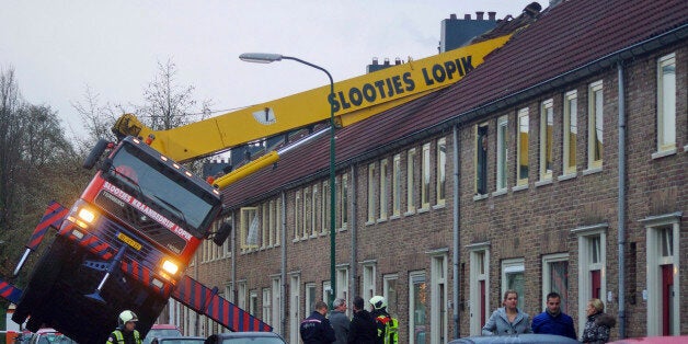 A crane which crashed into the roof of a house is seen following an unusual marriage proposal by a man who wished to be lifted in front of the bedroom window of his girlfriend to ask for her hand in marriage, in the central Dutch town of IJsselstein, Saturday Dec. 13, 2014. No people were injured in the accident, the groom-to-be jumped to safety without injuries and his girlfriend accepted to marry him, according to local Dutch media. (AP Photo/AS Media) NETHERLANDS OUT, MANDATORY CREDIT