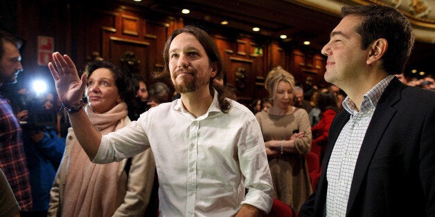 MADRID, SPAIN - NOVEMBER 15: New Podemos Party leader Pablo Iglesias (C) waves next to leader of Greece's left-wing political party Syriza, Alexis Tsipras (R) during a meeting to announce the elected Podemos Party members at Nuevo Apolo Theatre on November 15, 2014 in Madrid, Spain. Pablo Iglesias has been elected as general secretary of Podemos Party after gaining 95,311 (88.6 percent) votes through an internet poll. Podemos Party came out from the 'Indignants' and social movements. (Photo by