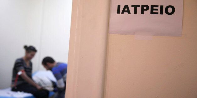 A drug user infected with the HIV virus, gives a blood sample at a public clinic in central Athens on Monday, Nov. 25, 2013. The sign on the door reads