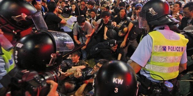 Police officers stop the protesters blocking the road after police cleared barricades and tents in Mong Kok district of Hong Kong, Wednesday Nov. 26, 2014. Police arrested key student leaders of Hong Kong's pro-democracy protests on Wednesday as they cleared barricades in one volatile district, throwing into doubt the future of a 2-month-old movement seeking free elections in the former British colony. (AP Photo/Kin Cheung)