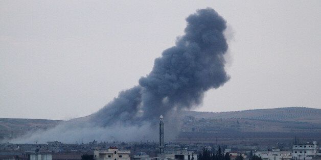 SANLIURFA, TURKEY - NOVEMBER 27: A photograph taken from Suruc district of Sanliurfa, Turkey, near Turkish-Syrian border crossing shows smoke rising from the Syrian border town of Kobani (Ayn al-Arab) following the US-led coalition airstrikes against the Islamic State of Iraq and the Levant (ISIL) targets on November 27, 2014. (Photo by Orhan Cicek/Anadolu Agency/Getty Images)