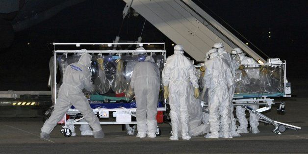 In this photo provided by the Italian Air Force, a KC 767 plane is parked on the tarmac as personnel in biohazard suits work by a stretcher encased in a plastic seal carrying a doctor who has tested positive for the Ebola virus, at the Pratica di Mare military airport near Rome, Tuesday, Nov. 25, 2014. The Italian health ministry says an Italian doctor working in Sierra Leone has tested positive for the Ebola virus and has been transferred to Rome for treatment. The ministry said in a statement that the doctor, who works for the non-governmental organization Emergency, will be taken Monday for treatment at the Lazzaro Spallanzani National Institute for Infectious Diseases in Rome. It is Italy's first confirmed case of Ebola. (AP Photo/Italian Air Force)