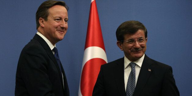 British Prime Minister David Cameron, left, and his Turkish counterpart Ahmet Davutoglu shake hands after a news conference in Ankara, Turkey, Tuesday, Dec. 9, 2014. Cameron also met President Recep Tayyip Erdogan and discussions are likely to focus on the fight against Islamic State group in Syria and Iraq. Cameron is expected to bring up the problem of British citizens entering Turkey in order to join IS group in Syria and Iraq.(AP Photo/Burhan Ozbilici)