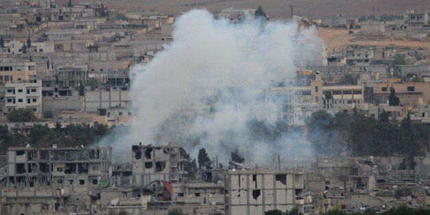 SANLIURFA, TURKEY - NOVEMBER 23: A photograph taken from Suruc district of Sanliurfa, southeastern province of Turkey, shows smoke rises during the clashes between the Islamic State of Iraq and Levant (ISIL) and armed troops in Kobani (Ayn al-arab) city of Syria, on November 23, 2014. (Photo by Halil Fidan/Anadolu Agency/Getty Images)