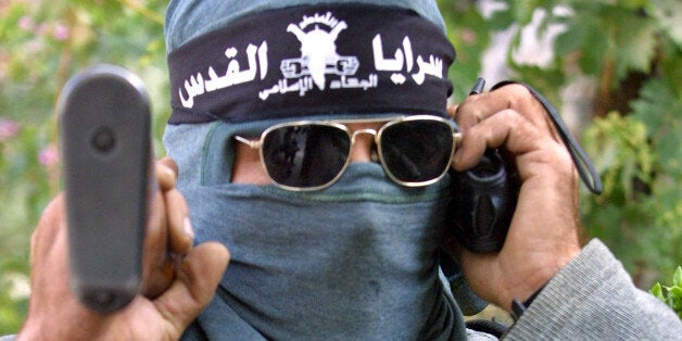 396194 10: A Palestinian gunman, from the militant Islamic Jihad group, uses a mobile phone to coordinate action against Israeli troops October 21, 2001 in the West Bank biblical town of Bethlehem. Israel maintained its armored closure over Palestinian towns, in the West Bank, after the assassination of Tourism Minister Rehavam Zeevi by suspected Palestinian gunmen last week. (Photo by David Silverman/Getty Images)