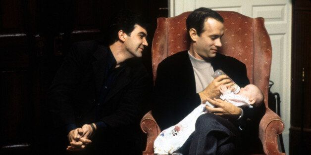 Tom Hanks feeds a baby while Antonio Banderas watches in a scene from the film 'Philadelphia', 1994. (Photo by TriStar/Getty Images)