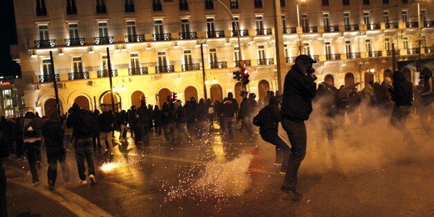 Protestors clash with riot police outside the parliament in Athens on December 6, 2011, during demonstrations to commemorate the police killing of a student three years ago which sparked violent riots lasting weeks. Pupils and students marched to mark the December 6, 2008 death of Alexis Grigoropoulos, 15, shot by police as Greece first came under pressure from the eurozone debt crisis. AFP PHOTO/ Angelos Tzortzinis (Photo credit should read ANGELOS TZORTZINIS/AFP/Getty Images)