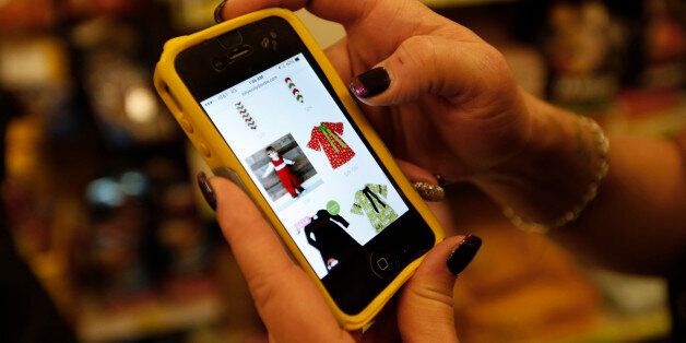 A Target customer looks at the Lollywollydoodle.com website on her smartphone on Black Friday, Nov. 28, 2014, in South Portland, Maine. (AP Photo/Robert F. Bukaty)