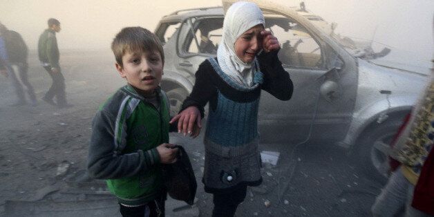 A girl cries near a damaged car at a site hit by what activists said were barrel bombs dropped by government forces in Aleppo's Dahret Awwad neighborhood January 29, 2014.