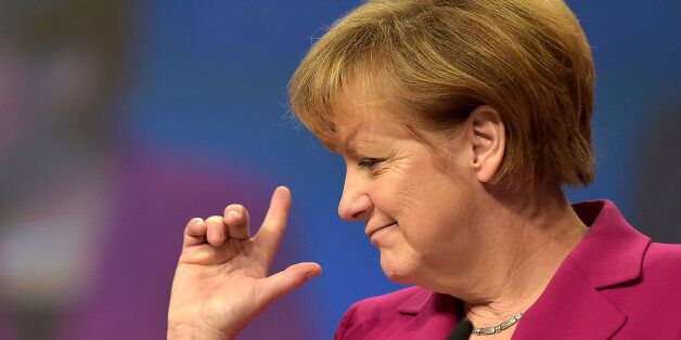German Chancellor and chairwoman of the German Christian Democrats, CDU, Angela Merkel, points with her fingers during a visit to the convention venue prior to the 27. party convention in Cologne, Germany, Monday, Dec. 8, 2014. (AP Photo/Martin Meissner)