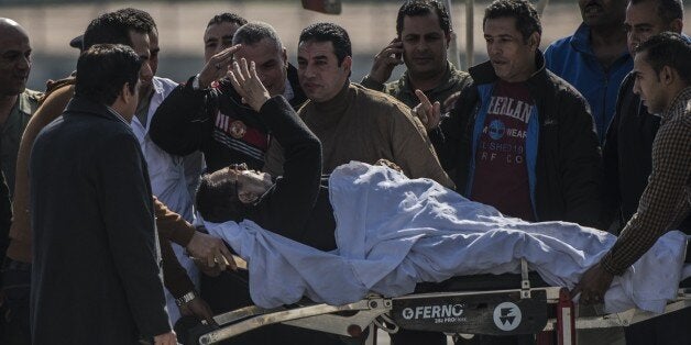 Egypt's former president Hosni Mubarak (C) waves as he is transported from a military helicopter to the ambulance outside Maadi military hospital in Cairo on November 29, 2014 after a court dismissed a murder charge against the ousted leader over the deaths of protesters during a 2011 uprising that ended the former strongman's decades-long rule. The court also acquitted Mubarak of a corruption charge, but he will remain in prison because he is serving a three-year sentence in a separate corruption case. AFP PHOTO / KHALED DESOUKI (Photo credit should read KHALED DESOUKI/AFP/Getty Images)