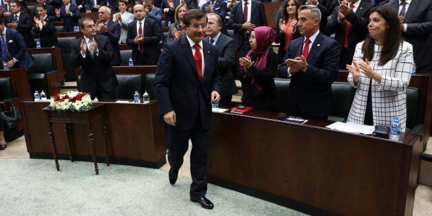 Turkey's Prime Minister Ahmet Davutoglu arrives to address members of the parliament of his ruling AK Party (AKP) during a session at the Turkish Parliament in Ankara on October 14, 2014. Turkish jets bombed targets in the southeast where members of the Kurdistan Workers' Party (PKK) are based, the first strikes on the outlawed group since a 2013 ceasefire, a security source said on October 14. AFP PHOTO/ADEM ALTAN (Photo credit should read ADEM ALTAN/AFP/Getty Images)