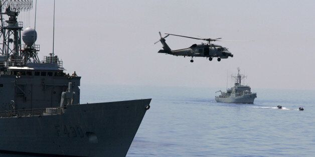 A Turkish Navy Blackhawk helicopter takes off from the Turkish frigate Gaziantep, left, as French Navy destroyer Piquet, right in the background, sets sail during the Anatolian Sun-06 military exercise in the Mediterranean Sea, off the coast of the southern Turkish city of Antalya, Friday, May 26, 2006. In a mock drill, Turkish commandos rappelled from military helicopters onto a merchant ship that intelligence said was carrying weapons of mass destruction, as U.S. commandos raced to join them from a nearby warship. The exercise, with 34 countries participating, was a practice session to prepare for intercepting weapons materials before they reach a country like Iran, Turkey's neighbor. (AP Photo/Murad Sezer)