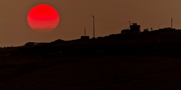 A soldier walks at a Turkish military outpost overlooking the Syrian city of Kobani, on a hilltop outside Suruc, on the Turkey-Syria border Monday, Nov. 17, 2014. Kobani, also known as Ayn Arab, and its surrounding areas, has been under assault by extremists of the Islamic State group since mid-September and is being defended by Kurdish fighters. (AP Photo/Vadim Ghirda)