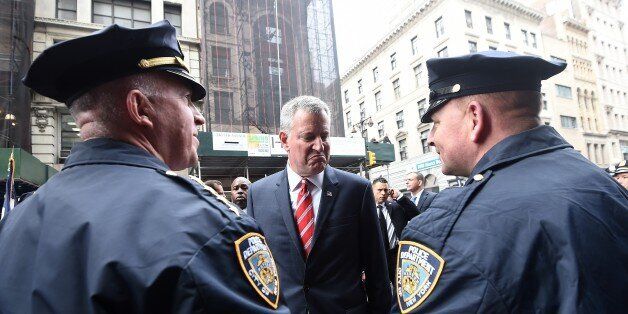 New York City Mayor Bill de Blasio (C) speaks with NYPD officers before a Veterans Day Parade in New York on November 11, 2014. AFP PHOTO/Jewel Samad (Photo credit should read JEWEL SAMAD/AFP/Getty Images)