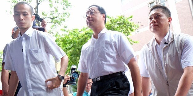 Taiwan's Premier Jiang Yi-huah (C) is escorted by the security staff as he arrives Taipei District Court on July 30, 2014. Jiang was in court to respond to allegations from students over clashes in March that saw riot police unleash water cannons to dislodge hundreds of demonstrators who had stormed the government headquarters in protest against a trade pact with China. AFP PHOTO / SAM YEH (Photo credit should read SAM YEH/AFP/Getty Images)