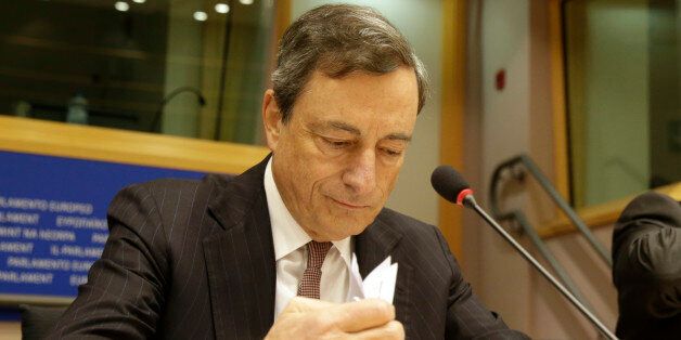 President of the European Central Bank Mario Draghi checks his papers prior to address the Committee on Economic and Monetary Affairs, at the European Parliament building, in Brussels on Monday, Nov. 17, 2014. (AP Photo/Yves Logghe)