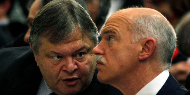 Greeces' Finance Minister Evangelos Venizelos, left, speaks to former Greek Prime Minister George Papandreou during a conference of PASOK socialist party at Faliro near Athens, Saturday, March 10, 2012. Greece's private creditors agreed Friday to take cents on the euro in the biggest debt writedown in history, paving the way for an enormous second bailout for the country to keep Europe's economy from being dragged further into chaos. (AP Photo/Kostas Tsironis)