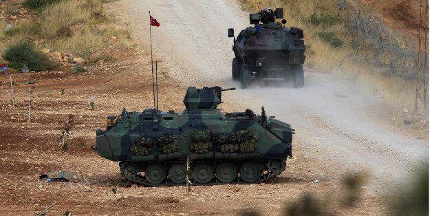Turkish army's armored vehicles stationed near the fighting positions between Syrian Kurds and Islamic State militants, about 10 kilometers in the west of Kobani in Syria, near Suruc, Turkey, Thursday, Oct. 2, 2014. Turkey's parliament approved a motion that gives the government new powers to launch military incursions into Syria and Iraq and to allow foreign forces to use its territory for possible operations against the Islamic State group(AP Photo/Burhan Ozbilici)