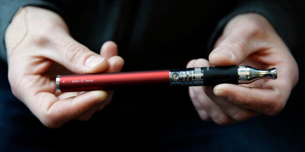 Eric Scheman holds an e-cigarette at Vape store in Chicago, Wednesday, April 23, 2014. The federal government wants to ban sales of electronic cigarettes to minors and require approval for new products and health warning labels under regulations being proposed by the Food and Drug Administration. (AP Photo/Nam Y. Huh)