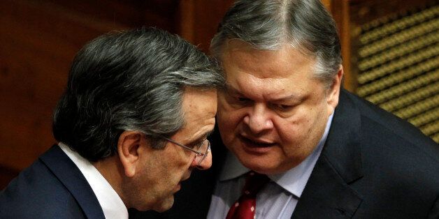 Greek Prime Minister Antonis Samaras, left, speaks with Socialist Leader Evangelos Venizelos at the Parliament during a debate on the new government's policy agenda before staging a vote of confidence in Athens, late Sunday July 8, 2012. (AP Photo/Kostas Tsironis)