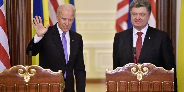 Ukrainian President Petro Poroshenko (R) stands as US Vice-President Joe Biden greet media after their statements for the results of their talks on November 21, 2014 in Kiev. US Vice-President Joe Biden warned that Russia risked further isolation over its 'unacceptable' aggression in Ukraine. The Ukrainian government hopes further US assistance for its forces, locked in a drawn-out struggle with pro-Moscow separatists in the east. AFP PHOTO/ SERGEI SUPINSKY (Photo credit should read SERGE