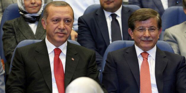 Turkey's president-elect Recep Tayyip Erdogan, left, and Foreign Minister Ahmet Davutoglu sit together during a party meeting in Ankara, Turkey, Thursday, Aug. 21, 2014. Davutoglu, hand-picked by Erdogan to succeed him as prime minister, is widely expected to accept a backseat role as his boss strives to make his new job the most powerful position in the land.(AP Photo/Burhan Ozbilici)