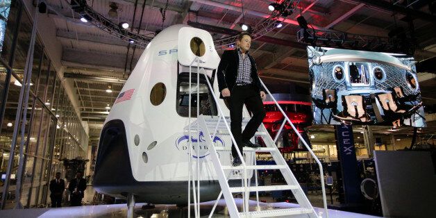 Elon Musk, CEO and CTO of SpaceX, walks down the steps while introducing the SpaceX Dragon V2 spaceship at the headquarters on Thursday, May 29, 2014, in Hawthorne, Calif. SpaceX, which has flown unmanned cargo capsules to the International Space Station, unveiled the new spacecraft Thursday designed to ferry astronauts to low-Earth orbit. (AP Photo/Jae C. Hong)