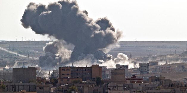 Smoke rises over the Syrian city of Kobani, following a US led coalition airstrike, seen from outside Suruc, on the Turkey-Syria border Monday, Nov. 10, 2014. Kobani, also known as Ayn Arab, and its surrounding areas, has been under assault by extremists of the Islamic State group since mid-September and is being defended by Kurdish fighters. (AP Photo/Vadim Ghirda)