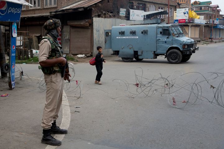 A Kashmiri boy walks past an Indian paramilitary soldier in Srinagar on August 7, 2019. Off record, senior police officers explained that a refusal to document those arrested allowed the police to evade responsibility.