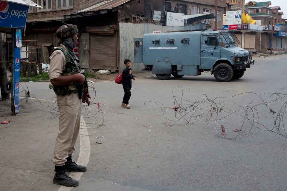 A Kashmiri boy walks past an Indian paramilitary soldier in Srinagar on August 7, 2019. Off record,...