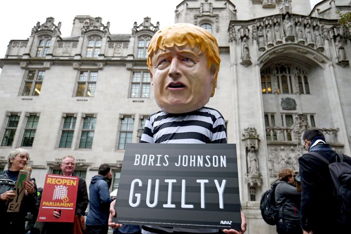 A man wearing a giant Boris Johnson mask, dressed as a prisoner, outside the Supreme Court in London.