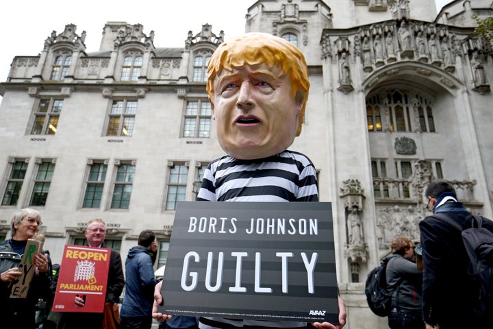 A man wearing a giant Boris Johnson mask, dressed as a prisoner, outside the Supreme Court in London.