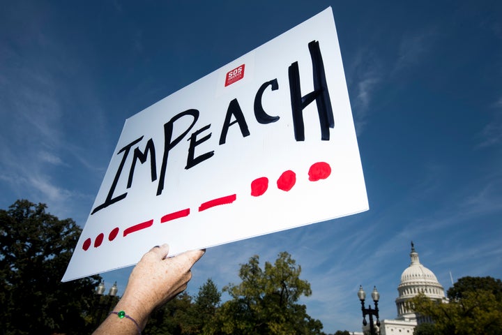 UNITED STATES - SEPTEMBER 23: A woman holds an impeach sign as Rep. Al Green, D-Texas, and Rep. Rashida Tlaib, D-Mich., speak to a group of protesters and the media about the need to impeach President Donald Trump in front of the Rayburn House Office Building on Monday, Sept. 23, 2019. The event was originally slated to coincide with the House Judiciary Committees hearing on corruption, but the hearing was postponed. (Photo By Bill Clark/CQ-Roll Call, Inc via Getty Images)