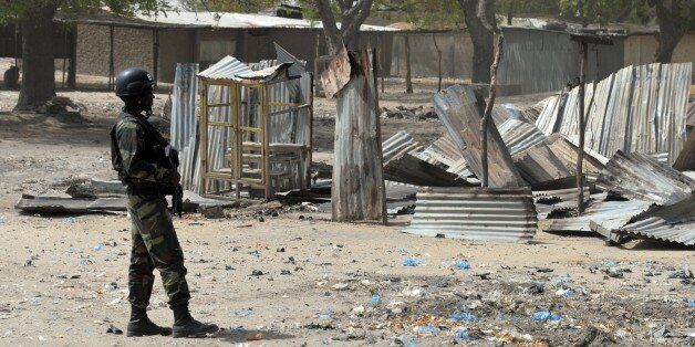 A picture taken on February 17, 2015 shows a Cameroonian soldier walking in the Cameroonian town of Fotokol, on the border with Nigeria, after clashes occurred on February 4 between Cameroonian troops and Nigeria-based Boko Haram insurgents. Nigerian Boko Haram fighters went on the rampage in the Cameroonian border town of Fotokol on February 4, massacring dozens of civilians and torching a mosque before being repelled by regional forces AFP PHOTO / REINNIER KAZE (Photo credit should read Reinnier KAZE/AFP/Getty Images)