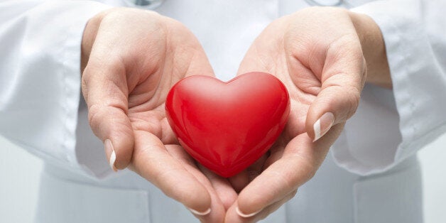 Female doctor with the stethoscope holding heart