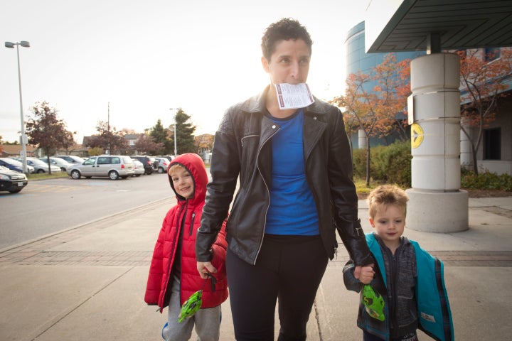 A mother goes to the polls with her two sons in Toronto, Oct. 19, 2015.