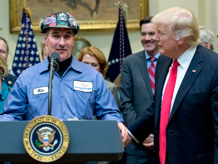 President Donald Trump gives the floor to a coal miner at the signing of a bill deregulating the industry. Warren's critics doubt her appeal with working-class voters.