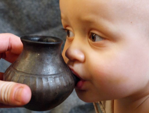 A baby is shown feeding from a reconstructed infant feeding vessel.
