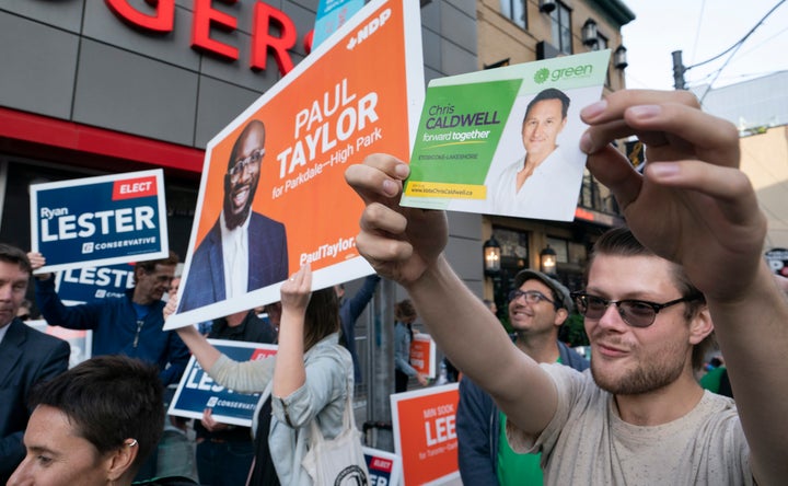 Supporters from various parties hold up campaign signs outside the studio of the first election debate in Toronto, on Thursday, Sept. 12, 2019. 