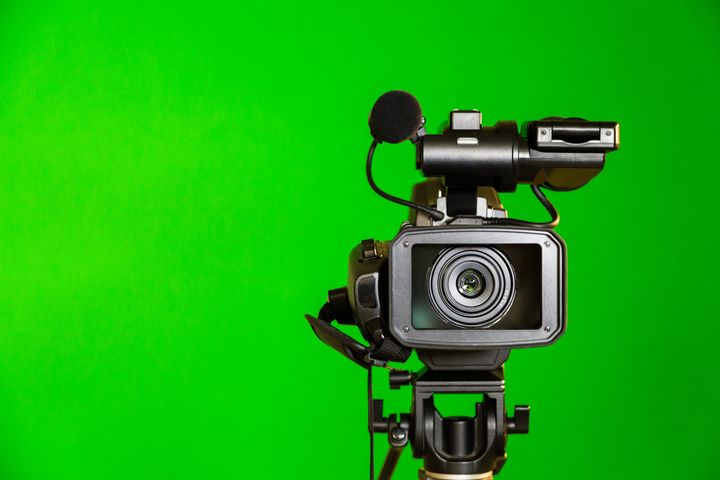 Camcorder on a green background. Filming in the interior. The chroma key.