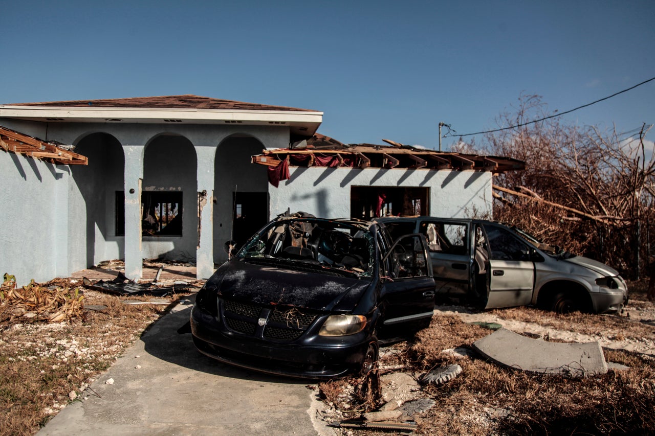 Crumpled vehicles sit outside Pastor Raymond Simozne's home in Freeport, Grand Bahama,.