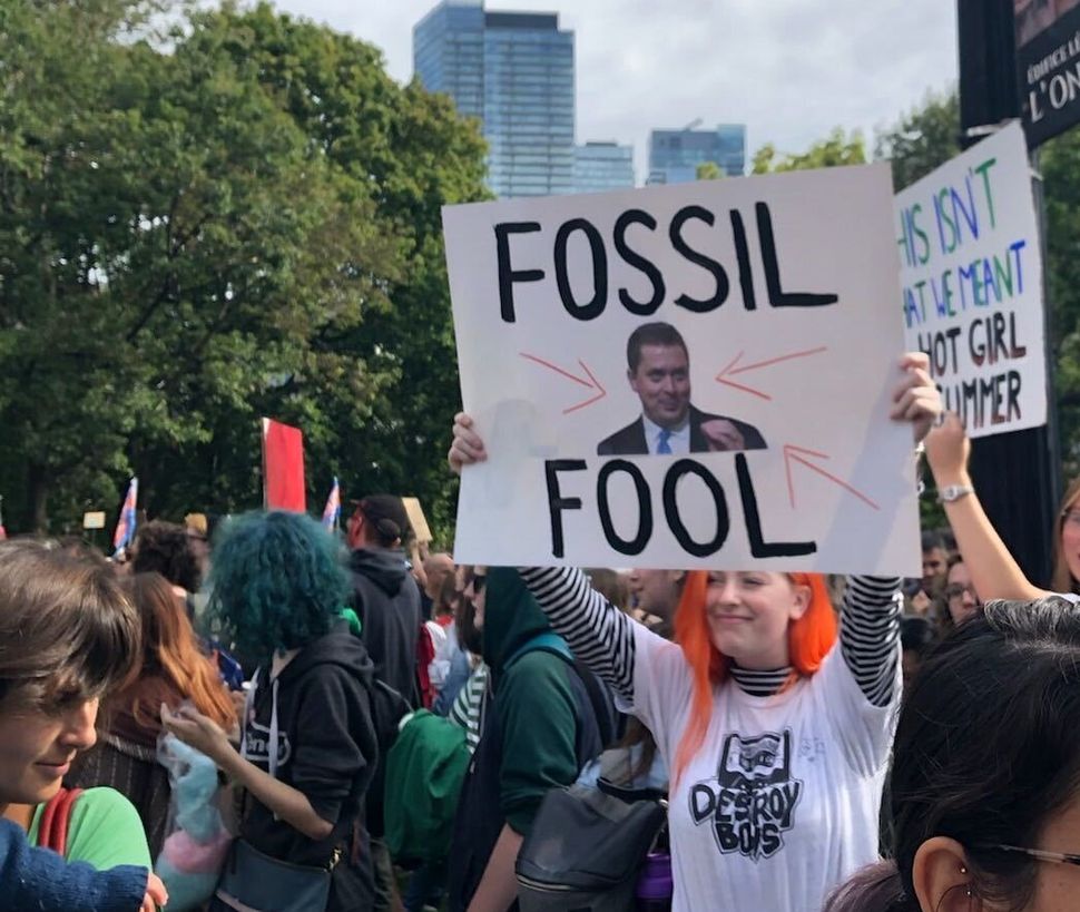A demonstrator pronounces Conservative Leader Andrew Scheer a "fossil fool" at a climate strike in Toronto on Sept. 27, 2019.